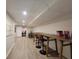 Spacious finished basement with drop ceiling, light gray floors, and long wooden work tables at 5430 Burdette Se Rd, Mableton, GA 30126