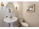 Classic powder room with a pedestal sink, decorative mirror, and a framed picture at 5430 Burdette Se Rd, Mableton, GA 30126