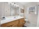 Well-lit bathroom featuring a wood vanity, a large mirror, and a shower with a white curtain at 5430 Burdette Se Rd, Mableton, GA 30126
