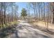 Scenic driveway view leading up to a classic home surrounded by mature trees, creating a private, wooded setting at 5430 Burdette Se Rd, Mableton, GA 30126