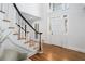 Bright foyer with hardwood floors, white staircase, and transom windows, creating an inviting entrance at 5430 Burdette Se Rd, Mableton, GA 30126