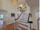 Grand foyer features a curved staircase with dark accents, hardwood floors, and an elegant light fixture at 5430 Burdette Se Rd, Mableton, GA 30126