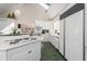 Well-lit kitchen with an island, white cabinets, stainless steel appliances and unique green brick floors at 5430 Burdette Se Rd, Mableton, GA 30126