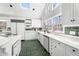 White kitchen features an island, skylights and green brick flooring at 5430 Burdette Se Rd, Mableton, GA 30126