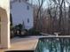 View of the sparkling pool with an umbrella-covered table and chairs next to mature trees at 5430 Burdette Se Rd, Mableton, GA 30126