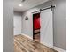 Hallway leads to theater with sliding barn door and hardwood floors at 363 Safe Harbor Dr, Dallas, GA 30157