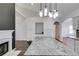 Bright kitchen featuring granite countertops, modern lighting, white cabinets, and a cozy fireplace at 363 Safe Harbor Dr, Dallas, GA 30157