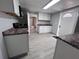 Efficient kitchen area with white cabinets, dark countertops, and light gray flooring at 3750 Clubhouse Se Ln, Conyers, GA 30094