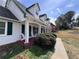 Cozy front porch with classic white columns, a red painted floor, and lush green bushes at 3750 Clubhouse Se Ln, Conyers, GA 30094