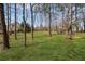 Lush green backyard with mature trees and a cozy firepit, creating a serene and private outdoor space at 4140 Hillsborough, Cumming, GA 30041