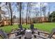 Inviting backyard fire pit area with Adirondack chairs and lush green lawn at 4140 Hillsborough, Cumming, GA 30041