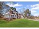 Side view of a beautiful brick home with a large, well-kept lawn and a welcoming front porch at 4140 Hillsborough, Cumming, GA 30041