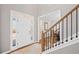 Bright and open foyer with hardwood floors, a staircase with a wooden railing, and a view into a sunny living space at 4140 Hillsborough, Cumming, GA 30041