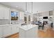 This modern, open-concept kitchen with hardwood floors overlooks a dining and living area. It features white cabinets at 4140 Hillsborough, Cumming, GA 30041