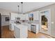 This modern kitchen is well-lit with white cabinets, stainless appliances, and an island with a white countertop at 4140 Hillsborough, Cumming, GA 30041