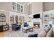 This living room features a fireplace with stone surround, hardwood floors, and large bright windows overlooking the backyard at 4140 Hillsborough, Cumming, GA 30041