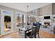 This dining area overlooks a living space with large bright windows, hardwood floors, and a stone fireplace at 4140 Hillsborough, Cumming, GA 30041