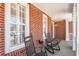 Inviting front porch with rocking chairs, brick facade, and shuttered windows, creating a cozy outdoor space at 4140 Hillsborough, Cumming, GA 30041