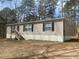 Tan single-story home with dark shutters surrounded by trees at 53 Oakview Dr, Carrollton, GA 30116