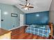 This bedroom features a ceiling fan, hardwood floors, and a modern blue accent wall at 539 Villa Rosa Rd, Temple, GA 30179
