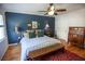Comfortable bedroom with blue walls, hardwood floors, area rug, and ceiling fan at 959 Hampton Nw Trl, Lilburn, GA 30047