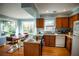Bright kitchen features wood cabinets, stainless appliances, and a dining table set by a large window at 959 Hampton Nw Trl, Lilburn, GA 30047