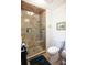 Modern shower with glass door, tiled walls, built-in niche, and convenient hand shower at 959 Hampton Nw Trl, Lilburn, GA 30047