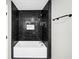 Sleek bathroom featuring a black marble tiled shower and tub with modern fixtures at 2478 Verbena Nw Cir, Atlanta, GA 30314
