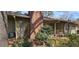 Rear exterior with brick chimney, covered porch, mature foliage, and seating at 4858 Westridge Dr, Norcross, GA 30093