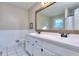 Bright bathroom featuring a double sink vanity, tile floors, and a large mirror at 684 Oak Moss Dr, Lawrenceville, GA 30043