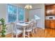 Bright dining room featuring a white table set, wood floors, a window view, and ample natural light at 684 Oak Moss Dr, Lawrenceville, GA 30043
