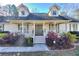 Inviting home with a covered front porch, decorative columns, and manicured landscaping at 684 Oak Moss Dr, Lawrenceville, GA 30043