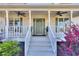 Comfortable front porch with ceiling fans, plants, and a view of landscaped yard at 684 Oak Moss Dr, Lawrenceville, GA 30043