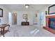 Bright living room featuring a fireplace, a ceiling fan, neutral carpet, and multiple entryways at 684 Oak Moss Dr, Lawrenceville, GA 30043