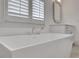 Close up of contemporary soaking tub with tile floors, and shaker cabinets in the updated bathroom at 2620 Middle Coray Cir, Marietta, GA 30066