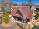 An aerial view of a stone and timber outdoor pavilion with seating and a stone fireplace and a rusted metal roof at 2620 Middle Coray Cir, Marietta, GA 30066
