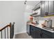 Bar area with dark cabinets, shelves, marble countertop, and beverage refrigerator at 3400 Palmer Lake Pointe, Douglasville, GA 30135