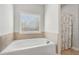 Bright bathroom with a bathtub, tiled floors, and a window that provides natural light at 3400 Palmer Lake Pointe, Douglasville, GA 30135