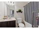 Bathroom featuring single sink vanity, toilet, tub with shower curtain, and shelving at 3400 Palmer Lake Pointe, Douglasville, GA 30135