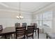 Elegant dining room featuring a tray ceiling, wainscoting, and a large window for natural light at 3400 Palmer Lake Pointe, Douglasville, GA 30135