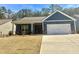 Charming blue single-story home featuring an attached two-car garage and well-maintained front yard at 8325 Loch Lomand Ln, Winston, GA 30187