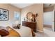 Well-lit bedroom with neutral tones, featuring a dresser, round mirror, and an exterior door for easy access at 301 Oldvine Dr, Lawrenceville, GA 30044