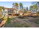 Backyard features a well-maintained lawn, stone retaining wall, a cozy fire pit, and a screened porch on the house at 3672 Howell Wood Nw Trl, Duluth, GA 30096
