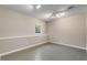 A spacious basement features neutral walls, track lighting, and a window for natural light at 3672 Howell Wood Nw Trl, Duluth, GA 30096