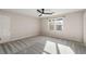 Bedroom with natural light and carpeted floor features a door, a window and a ceiling fan at 3672 Howell Wood Nw Trl, Duluth, GA 30096