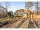Home exterior with landscaped yard, back deck, screened porch, and stone retaining walls at 3672 Howell Wood Nw Trl, Duluth, GA 30096