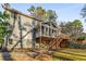 Back of home featuring a screened porch, wooden deck, walkout basement, and lush backyard at 3672 Howell Wood Nw Trl, Duluth, GA 30096