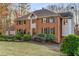Two-story brick home with mature landscaping, dark shutters, and a side-entry garage at 3672 Howell Wood Nw Trl, Duluth, GA 30096