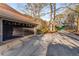 Exterior view of a two-car garage and driveway, set against mature trees and landscaping at 3672 Howell Wood Nw Trl, Duluth, GA 30096