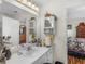 Well-lit bathroom with a white vanity, mirrored medicine cabinet and view to the bedroom at 507 Mockingbird Ln, Loganville, GA 30052